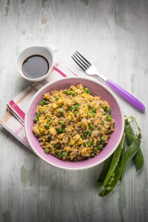 barley risotto woth green peas scramble eggs and soy sauce Stock Photo